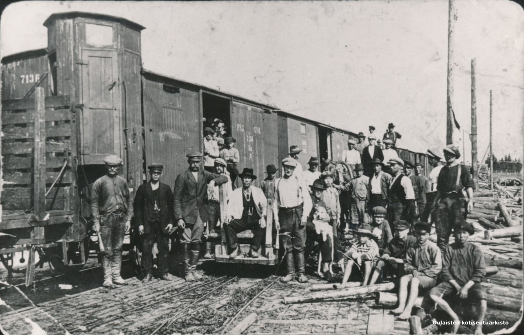 Oulaisten sahan työntekijöitä lastaamassa puuta junaan